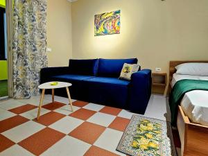 a living room with a blue couch and a bed at Lemon House Borsh in Himare