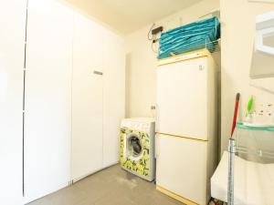 a laundry room with a refrigerator and a washing machine at Holiday Home La Gabane quiet but central house by Interhome in De Haan