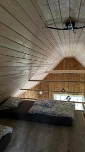 a bedroom with a large bed in a wooden wall at Domek nad Uroczyskiem in Piotrowice
