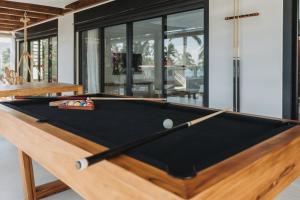a pool table in a living room at Charles - magnifique villa neuve avec piscine et accès direct à la plage in Saint-Gilles les Bains