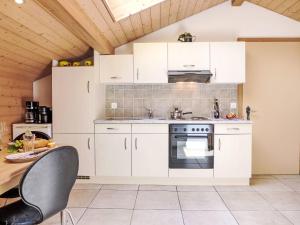 a kitchen with white cabinets and a table at Apartment Bühl by Interhome in Achseten