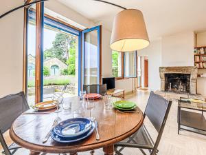 una sala da pranzo con tavolo, sedie e camino di Holiday Home La petite Pen Er Hoët by Interhome a La Trinité-sur-Mer Altre 20 foto