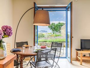 una sala da pranzo con tavolo, sedie e porta scorrevole in vetro di Holiday Home La petite Pen Er Hoët by Interhome a La Trinité-sur-Mer