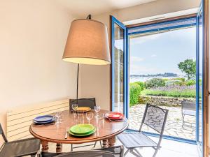una sala da pranzo con tavolo, sedie e porta scorrevole in vetro di Holiday Home La petite Pen Er Hoët by Interhome a La Trinité-sur-Mer