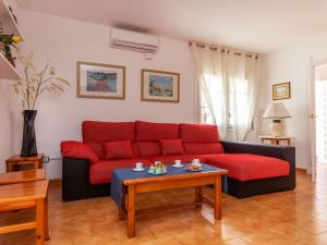 a living room with a red couch and a table at Holiday Home Salze by Interhome in Hospitalet de l'Infant