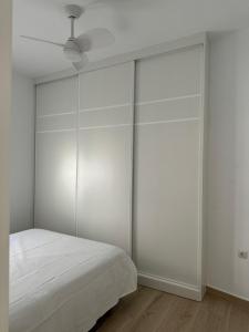 a white bedroom with a bed and a ceiling at Casa Rural El Almendro in Fernán Pérez