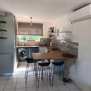 a kitchen with a wooden table and chairs in it at Ramsgate Beachfront - Ramsgate Palms AA 50 in Margate