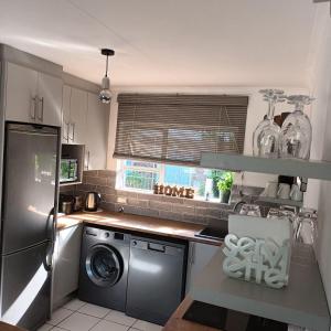 a kitchen with a washing machine and a window at Ramsgate Beachfront - Ramsgate Palms AA 50 in Margate +7 photos