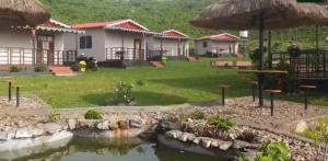 BāghmundiGitanjali Forest Retreat的享有带池塘的度假胜地的景致