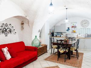 a living room with a red couch and a kitchen at Holiday Home Ca da Nair by Interhome in Castellaro +23 photos