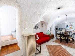 a living room with a red couch and a table at Holiday Home Ca da Nair by Interhome in Castellaro