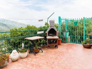 a patio with a grill and a table and plants at Holiday Home Ca da Nair by Interhome in Castellaro