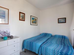 a bed with a blue comforter in a bedroom at Apartment Azur 3000 by Interhome in Saint-Laurent-du-Var
