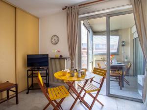 a living room with a yellow table and chairs at Apartment Azur 3000 by Interhome in Saint-Laurent-du-Var +13 photos