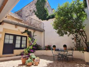 a patio with a table and chairs in front of a building at Les Songes d'Augustine in Aigues-Vives