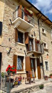 a building with a balcony and flowers on it at B&B dalla Eli in Bosco Chiesanuova