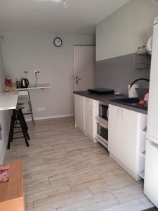 a kitchen with white cabinets and a wooden floor at 3Rooms Wrzeszcz in Gdańsk