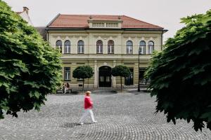 a person walking in front of a building at Villa Elizabeth - Grand Family Apartment in Slovenj Gradec