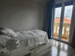 a bedroom with a bed and a large window at Piso centrico amplio-luminoso in Zarautz