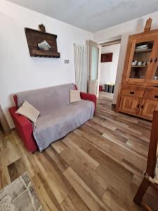 a living room with a bed and a wooden floor at Appartamento sul Lago di Maen in Valtournenche +7 photos