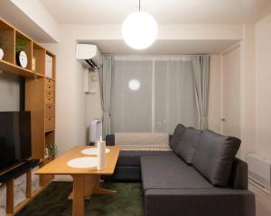 a living room with a couch and a table at Mondomio 510 in Sapporo
