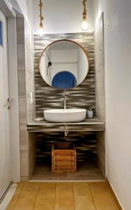 a bathroom with a sink and a mirror at Bralos Apartments in Patitiri