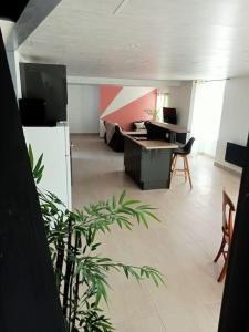 Una sala de estar con un escritorio, una mesa y sillas. en Gite 6 personnes à Alrance, en Alrance 3 fotos más