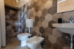 a bathroom with a toilet and a sink at Case Mediterranee in Modica