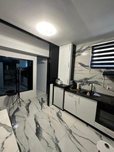 a kitchen with marble floors and a large window at Garsoniera Zona Stadion in Craiova