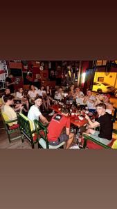 un gruppo di persone seduti ai tavoli in un ristorante di Hostel Chilli a Tirana
