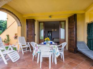 Un patio con una mesa y sillas en un porche. en Holiday Home Bellavista-3 by Interhome, en Castellina Marittima