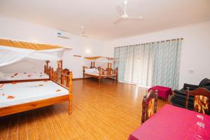 a bedroom with two bunk beds and a living room at Zanzibar Kivinjeni Beach Bungalows in Mfumbwi