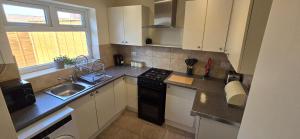 a kitchen with a sink and a stove top oven at Eastpark 5 bdrms Walk to O2 Apollo and City in Manchester