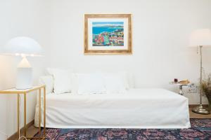 a bedroom with a white bed with a picture on the wall at Hedera Estate Hedera A8 in Dubrovnik