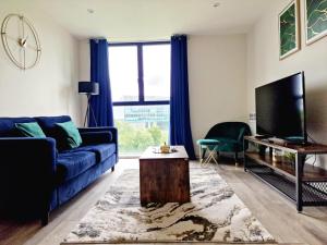a living room with a blue couch and a tv at Westminster Luxury Liverpool Apartment with Free Parking in Liverpool
