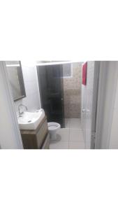 a bathroom with a toilet and a sink and a shower at Casa com Piscina e Ar Condicionado in Imbé