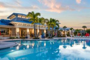 a large swimming pool with palm trees in front of a building at 3787 Elegant 6BD Island Getaway Windsor Resort in Davenport