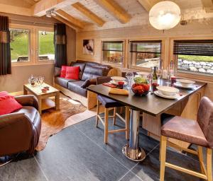 a living room with a table and a couch at Chalet Inarpa - Appartements et Suites in La Clusaz