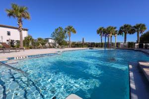 a swimming pool with blue water and palm trees at 216 Oasis Magic 4BD Villa 5 Min to Disney Magic in Loughman