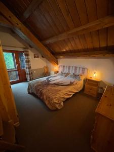 a bedroom with a large bed with a wooden ceiling at Splendida Carezza in Carezza al Lago