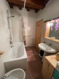 a bathroom with a tub and a toilet and a sink at Splendida Carezza in Carezza al Lago
