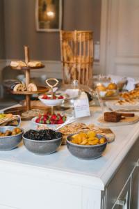 a buffet of food on a counter with bowls of food at Chateau du Clos de la Ribaudiere - Teritoria in Chasseneuil-du-Poitou