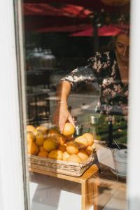 a woman standing behind a table with a basket of oranges at Chateau du Clos de la Ribaudiere - Teritoria in Chasseneuil-du-Poitou