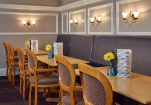 a dining room with a wooden table and chairs at Lancaster Gate Hotel in London