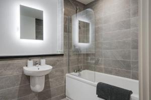 a bathroom with a sink and a toilet and a bath tub at Westminster Luxury Liverpool Apartment with Free Parking in Liverpool +10 photos