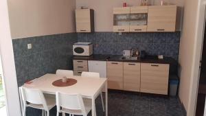 a kitchen with a white table and white chairs at Igalo Vuke in Igalo