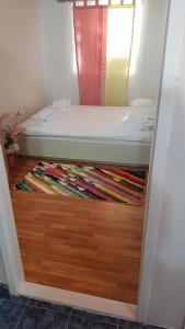 a bedroom with a bed on top of a wooden floor at Igalo Vuke in Igalo +6 photos