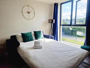 a bedroom with a large bed with a clock on the wall at Westminster Luxury Liverpool Apartment with Free Parking in Liverpool
