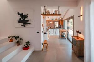 a living room with white walls and a table and some plants at Villa Andrea in Cefalù