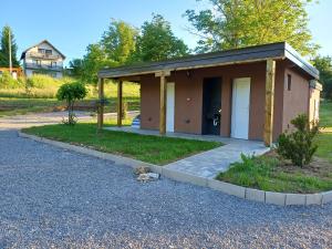 a small building with a porch and a driveway at Eko Kamp odmorište Brig in Duga Resa